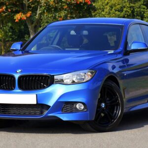 Modern blue luxury car parked by a scenic roadside on a sunny day. Stylish design.